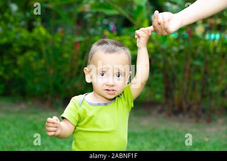 Happy Toddler Boy Learning to Walk in the Grass Stock Photo
