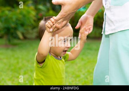 Happy Toddler Boy Learning to Walk in the Grass Stock Photo