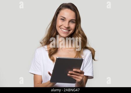 Happy smiling young woman using tablet computer, looking at camera Stock Photo