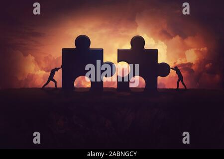 Two determined businessman pushing big jigsaw puzzle pieces to unite and complete the purpose. Business teamwork concept, achieving success together b Stock Photo