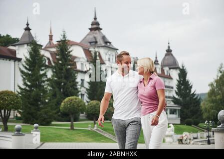 A handsome couple, man and a woman walking together holding hands. The concept of middle-aged relationships Stock Photo