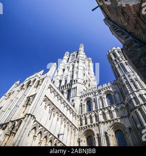 Ely Cathedral, Cambridgeshire UK. Low, wide angle view of the historic cathedral in the Fenland city of Ely with bright blue cloudless copy space sky. Stock Photo