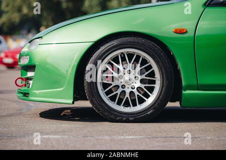 KYIV-28 JULY,2019: JDM car show outdoor.Tuned Japanese drift cars expo in summer.Modified green Mazda 323F vehicle on low profile tires and custom rim Stock Photo