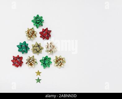 Christmas tree shape made of bows and stars, isolated on a white background with copy space Stock Photo