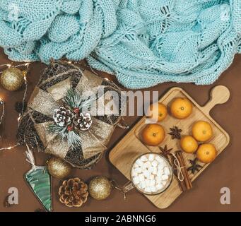 New Year flat lay with golden gift,balls,lights,cones,cinnamon and anice star,caramel on a brown background Stock Photo