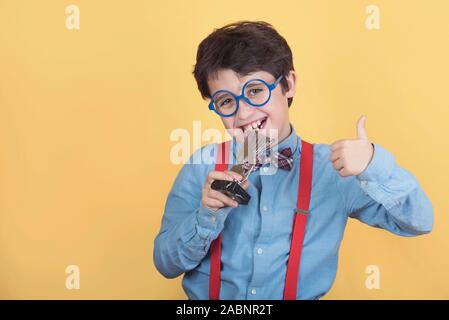 Happy boy with winning cup on yellow background Stock Photo