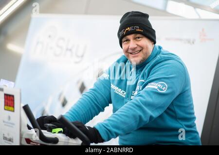 Munich, Germany. 28th Nov, 2019. Franz Müllner, strength athlete, warms up on a trimming bike before his world record attempt. The extreme sportsman from Austria was able to set a new world record with the turning of the 750 ton giant wheel. Credit: Matthias Balk/dpa/Alamy Live News Stock Photo