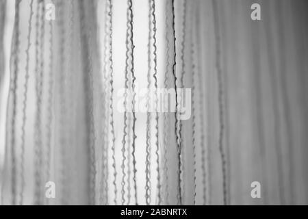 Delicate tulle with vertical threads pattern, side view, bw photo. Stock Photo