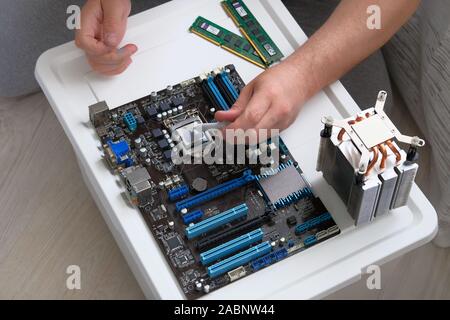 Service electronics and computers concept. Thermal grease for computer. Male hand applied thermal paste to processor. Stock Photo