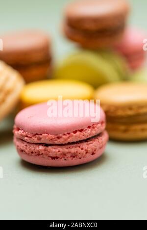 Colored tasty  macaroons over a green background. Stock Photo