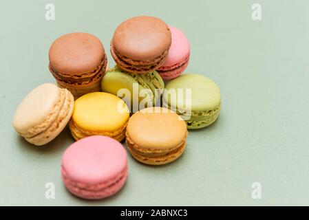 Colored tasty  macaroons over a green background. Stock Photo