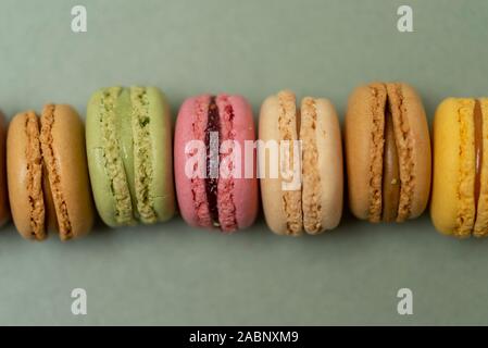 Colored tasty  macaroons over a green background. Stock Photo