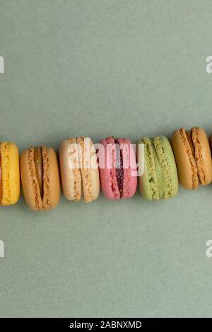 Colored tasty  macaroons over a green background. Stock Photo
