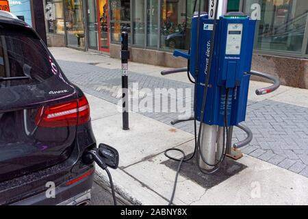 An electric car at an EV charging station in downtown Montreal, Quebec, Canada Stock Photo