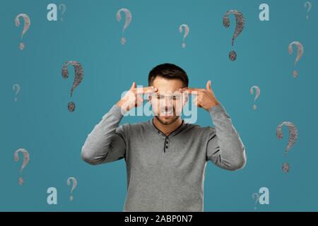 portrait of doubtful bearded man asking questions isolated on blue background. Stock Photo