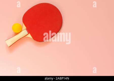 Red tennis ping pong racket isolated on a pink background, sport equipment for table tennis Stock Photo