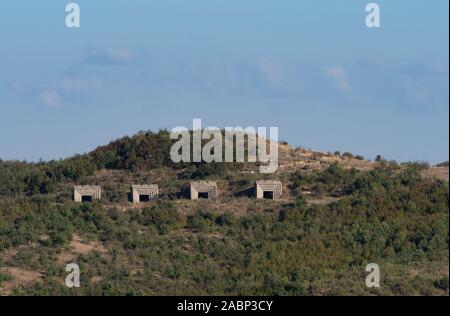 Four concrete bunkers built into a hill during Enver Hoxha's rule in the Soviet era in Albania. Stock Photo