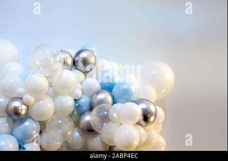 many colored balloons forming a bright background wallpaper image. white. silver. blue balloons as textured backdrop. Stock Photo
