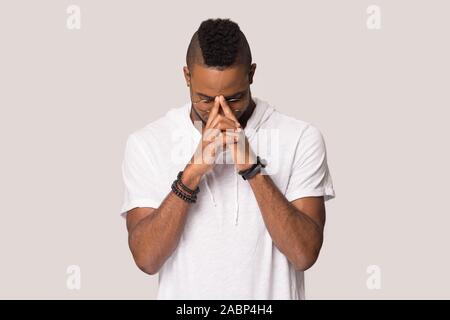 Concentrated young African American man thinking, praying Stock Photo