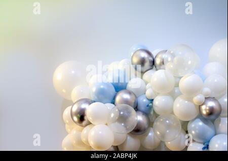 many colored balloons forming a bright background wallpaper image. white. silver. blue balloons as textured backdrop. Stock Photo