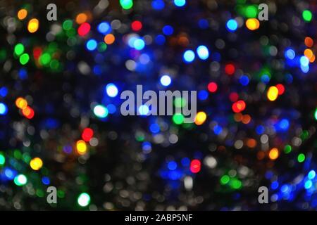 Blurred Christmas, New-year multicolored lights, dark background Stock Photo