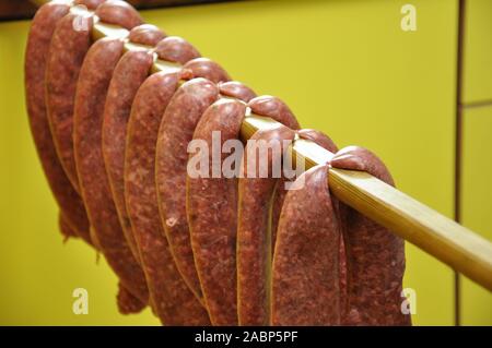 A row of raw sausages being cured Stock Photo