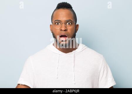 Shocked scared African American man in glasses looking at camera Stock Photo
