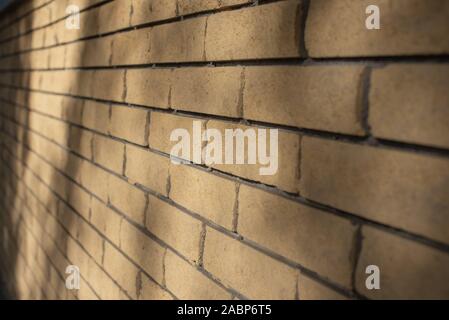 Yellow brick wall. The texture of the brick wall. Background for designers. Light and shadow on a beige brick wall with brick Stock Photo