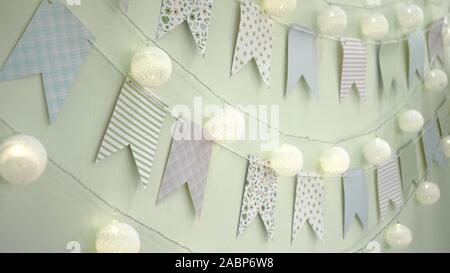 Wall is decorated with multi-colored flags for children. Birthday decor, decoration flags. Decor for the holiday Stock Photo