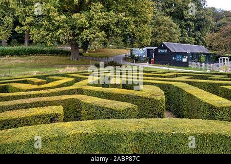 Kent, United Kingdom - October 09, 2019. Intricate hedge maze with a charming visitor center in a park setting by the Leeds Castle. Stock Photo