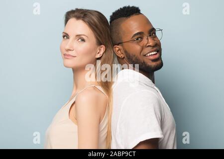 Smiling African American man and woman standing back to back Stock Photo