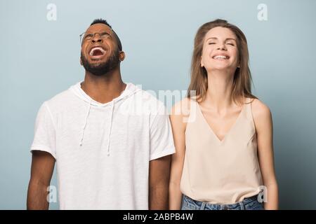 Happy diverse man and woman laughing at hilarious joke together Stock Photo
