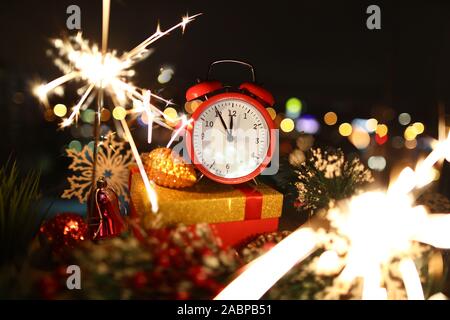 Red alarm clock with christmas gifts against night Stock Photo