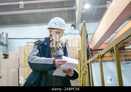 Production workshop. Young female engineer working in modern factory Stock Photo