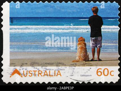 Man & dog watching the ocean, australian postage stamp Stock Photo