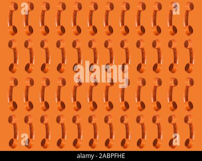 Seamless pattern of an orange retro style telephone, isolated on an orange background Stock Photo