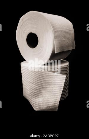 stacked rolls of toilet paper on black background Stock Photo