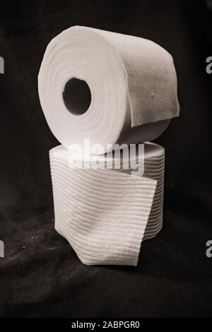 stacked rolls of toilet paper on black background Stock Photo