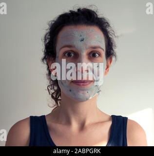A woman pampering herself with a fresh blueberry face mask up-close. Stock Photo