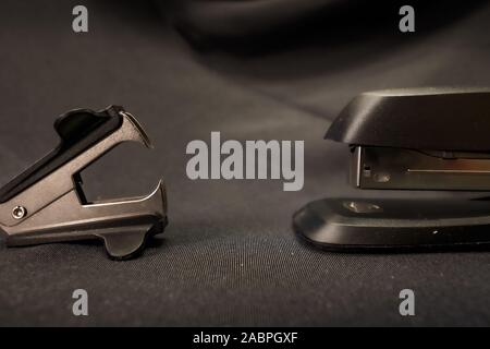 Stapler verses staple remover Office conflict example Stock Photo