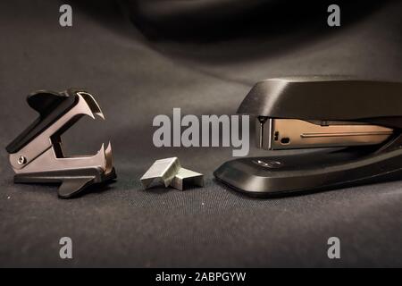 Stapler verses staple remover Office conflict example Stock Photo
