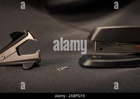 Stapler verses staple remover Office conflict example Stock Photo