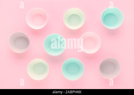silikone forms for baking muffins and cupcakes on pastel pink background Stock Photo