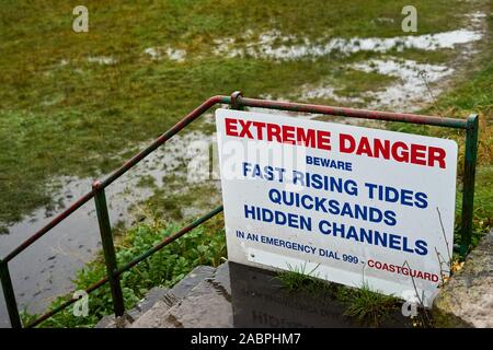 Warning sign 'Extreme Danger Beware Fast Rising Tides Quicksands Hidden Channel' at Arnside, Cumbria, UK Stock Photo