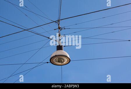 Street lamp hanging on wires against blue sky background Stock Photo