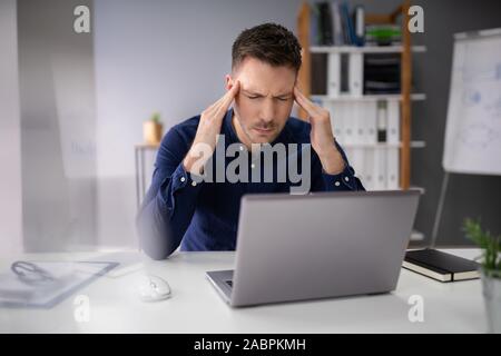 Stressful Business Man Working On Laptop In Office Stock Photo