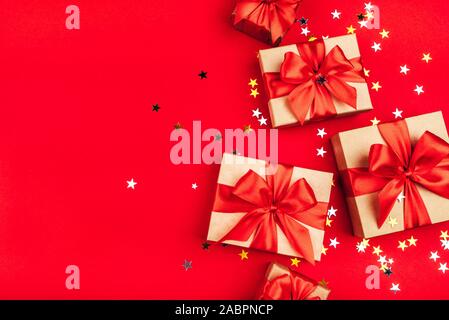 Several gift boxes with bows on a red background. Stock Photo