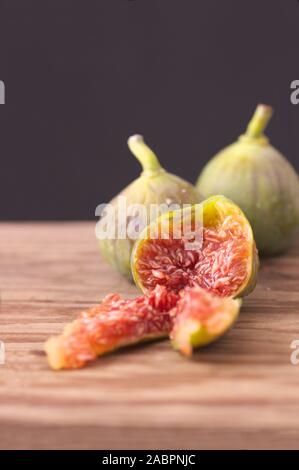 Image of some ripe figs on a wooden board with dark background Stock Photo