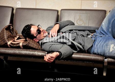 a blind, in one eye, Caucasian Man sleeping in Phoenix airport while waiting for his airplane to the UK Stock Photo