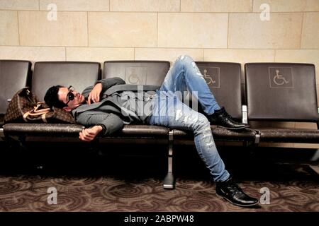 a blind, in one eye, Caucasian Man sleeping in Phoenix airport while waiting for his airplane to the UK Stock Photo
